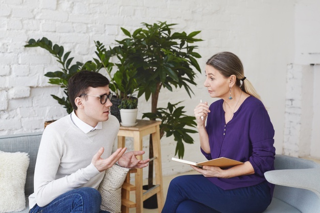 psychology-therapy-psychiatry-mental-health-counseling-concept-candid-shot-nervous-self-conscious-young-male-glasses-telling-middle-aged-female-counselor-about-his-problems-work_344912-1940